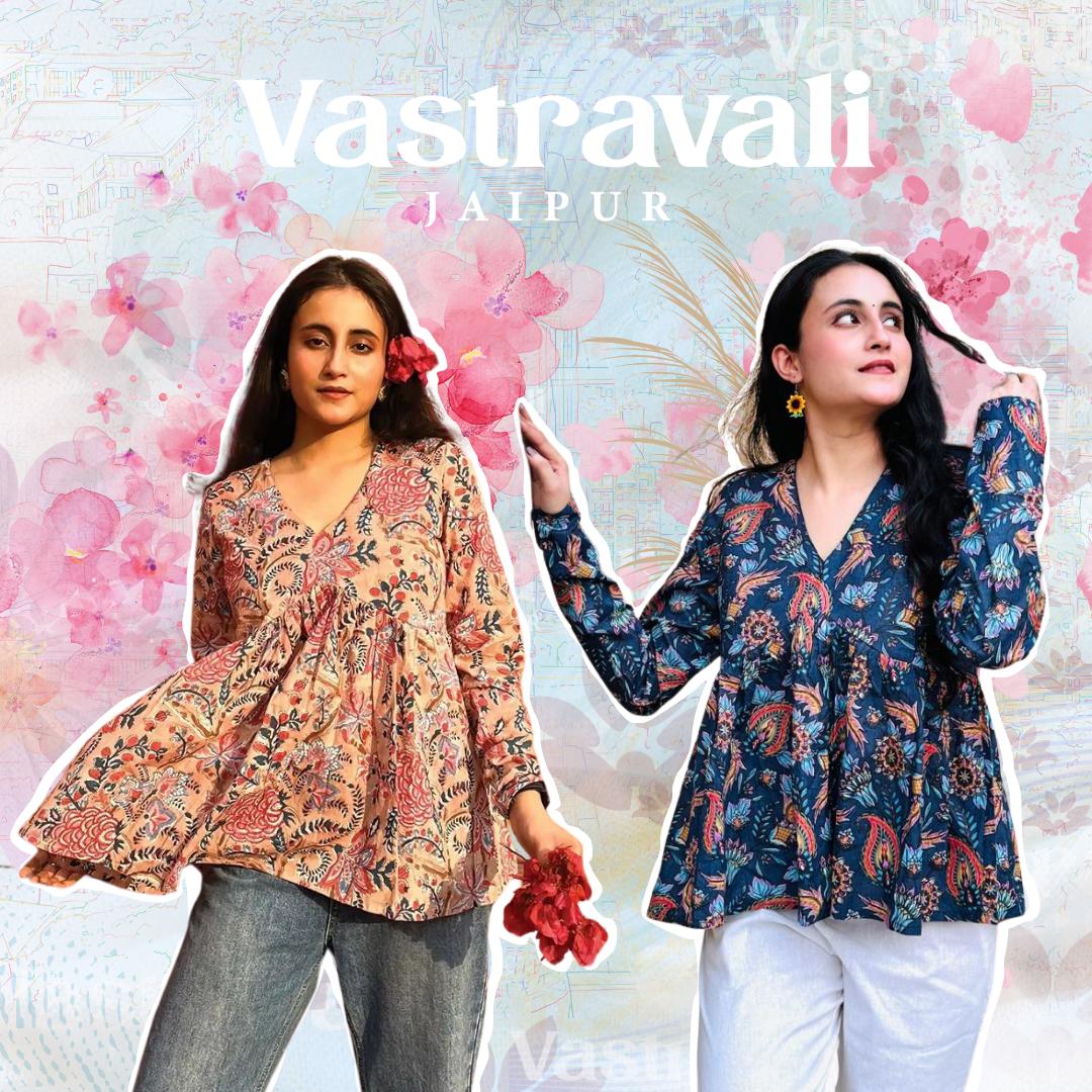 Two women modeling traditional floral and paisley tops in different colors against a floral background. One woman is modeling a pink floral top, and the other is wearing a dark blue paisley top.