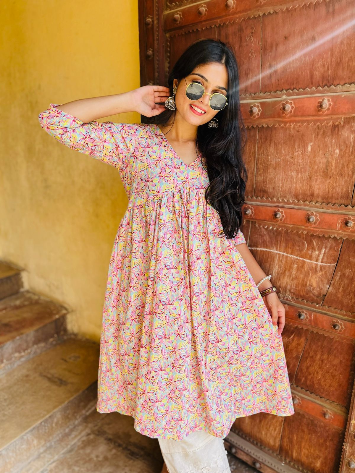 A woman wearing a pink floral cotton kurti