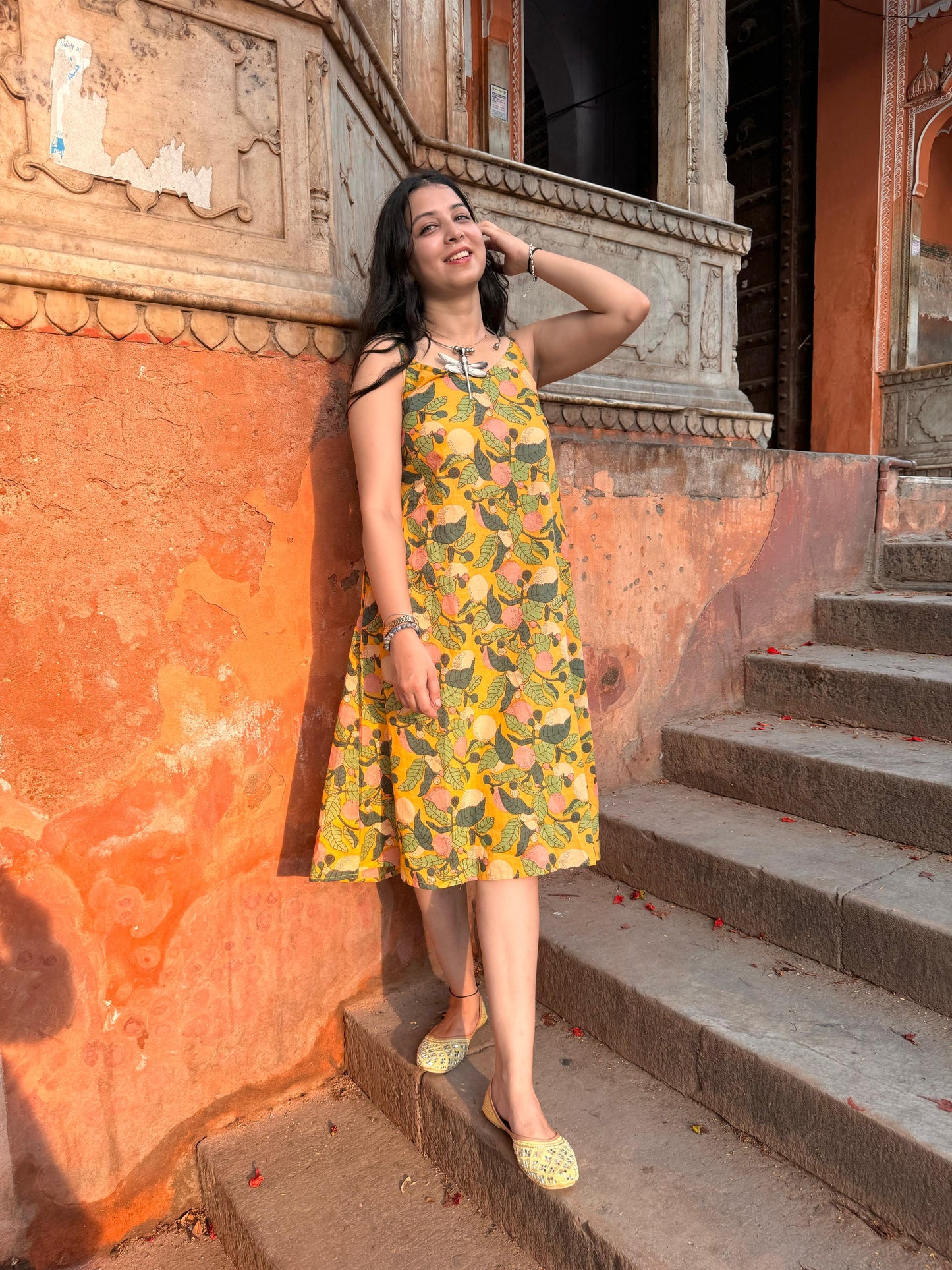 A woman wearing a yellow floral cotton summer dress