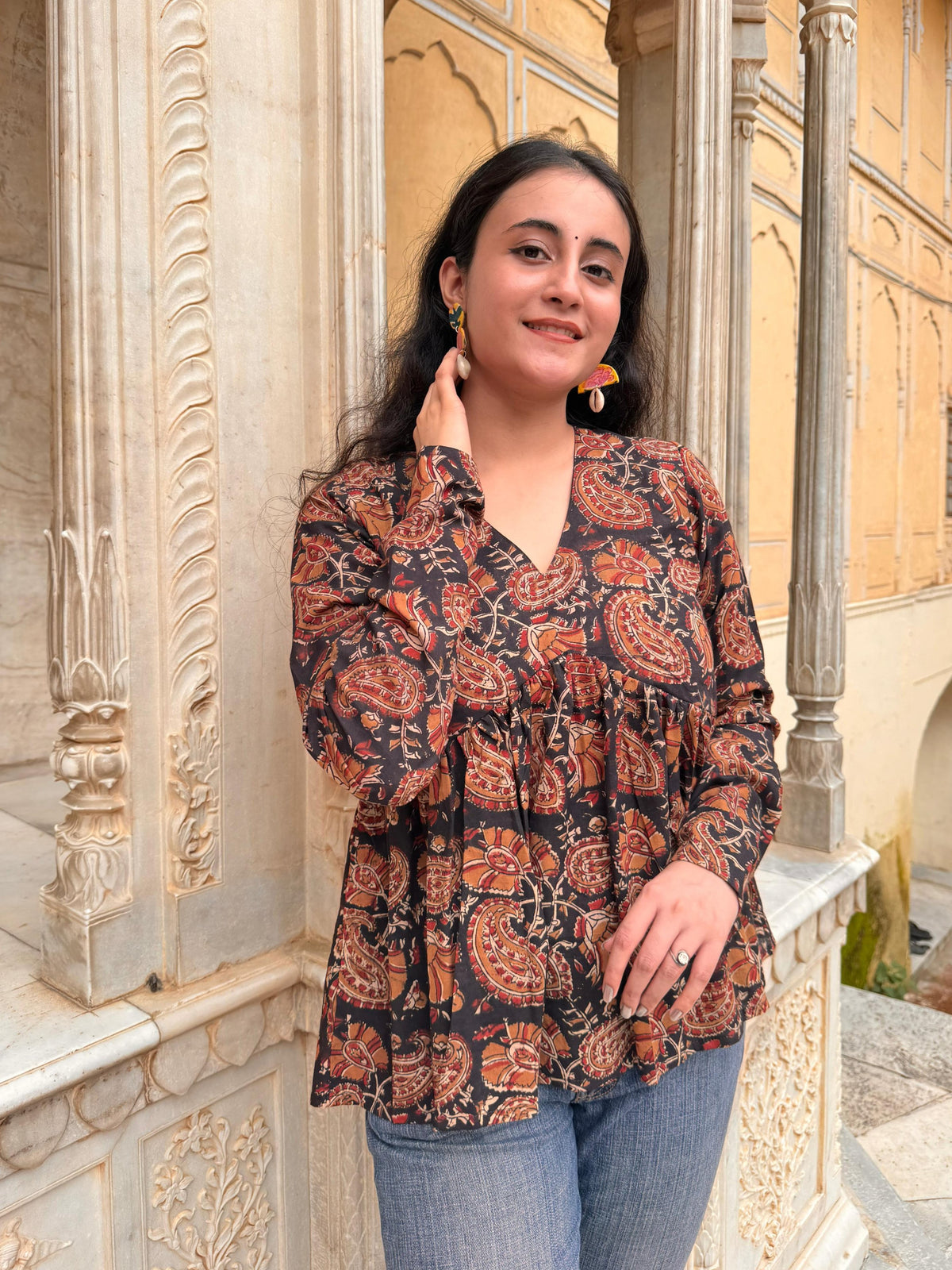 A woman wearing a black floral cotton top
