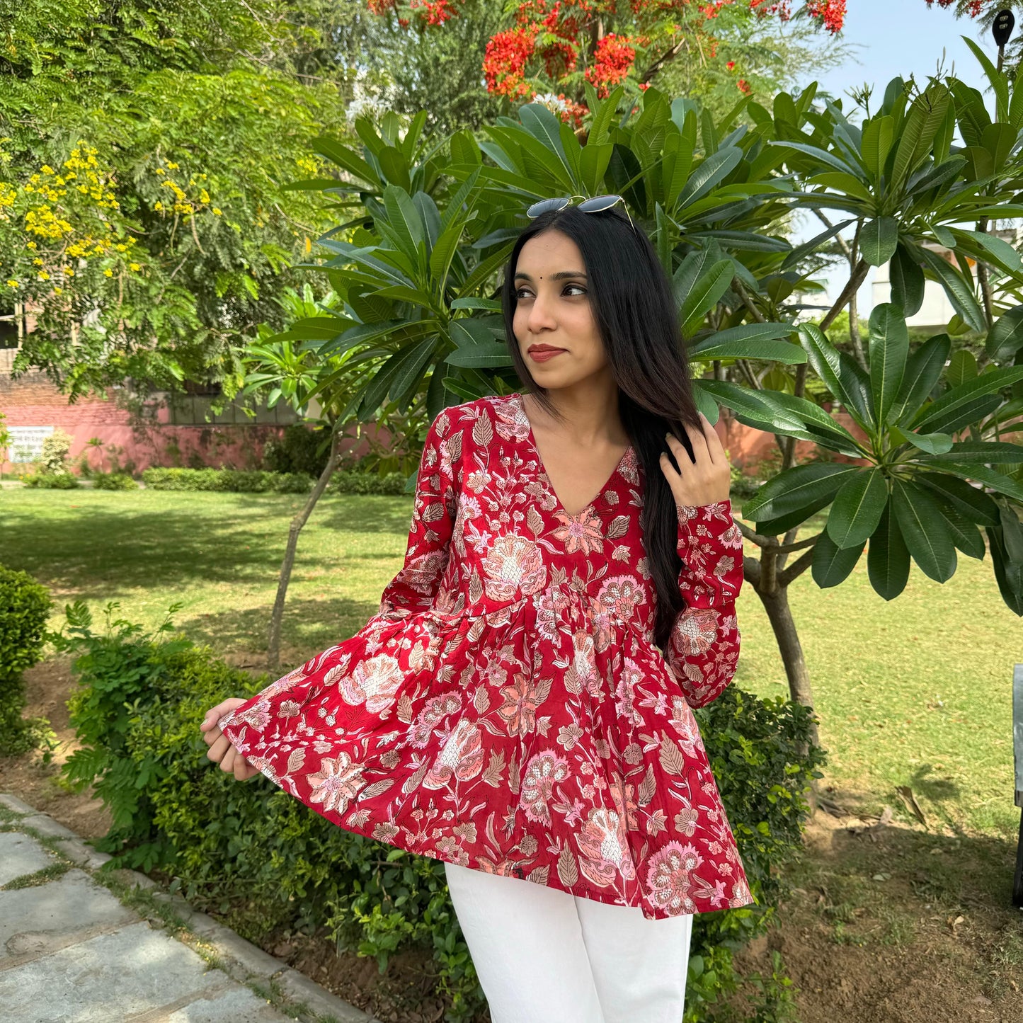 A woman wearing a red floral cotton top
