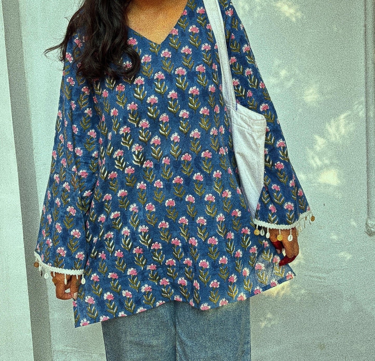 Woman wearing a blue floral patterned jacket against a light background