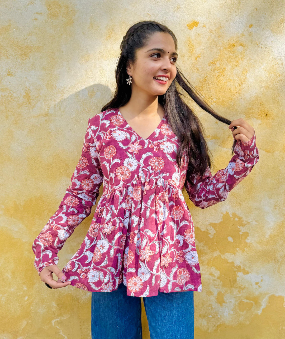 A woman wearing a floral hand-block printed, red kurta with a flared Alia-cut style.