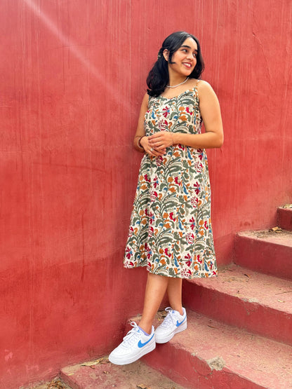 A woman standing on a set of stairs, wearing a floral hand block printed summer dress.