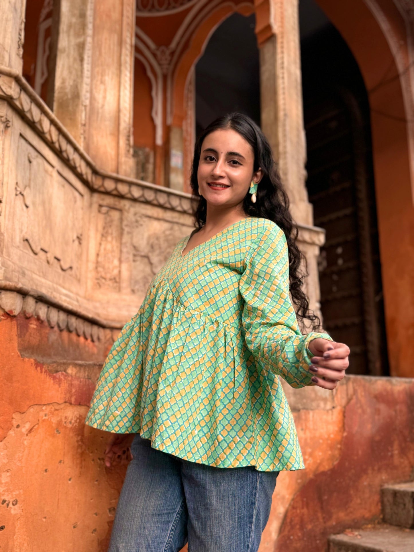  A woman wearing a green or yellow floral cotton peplum top