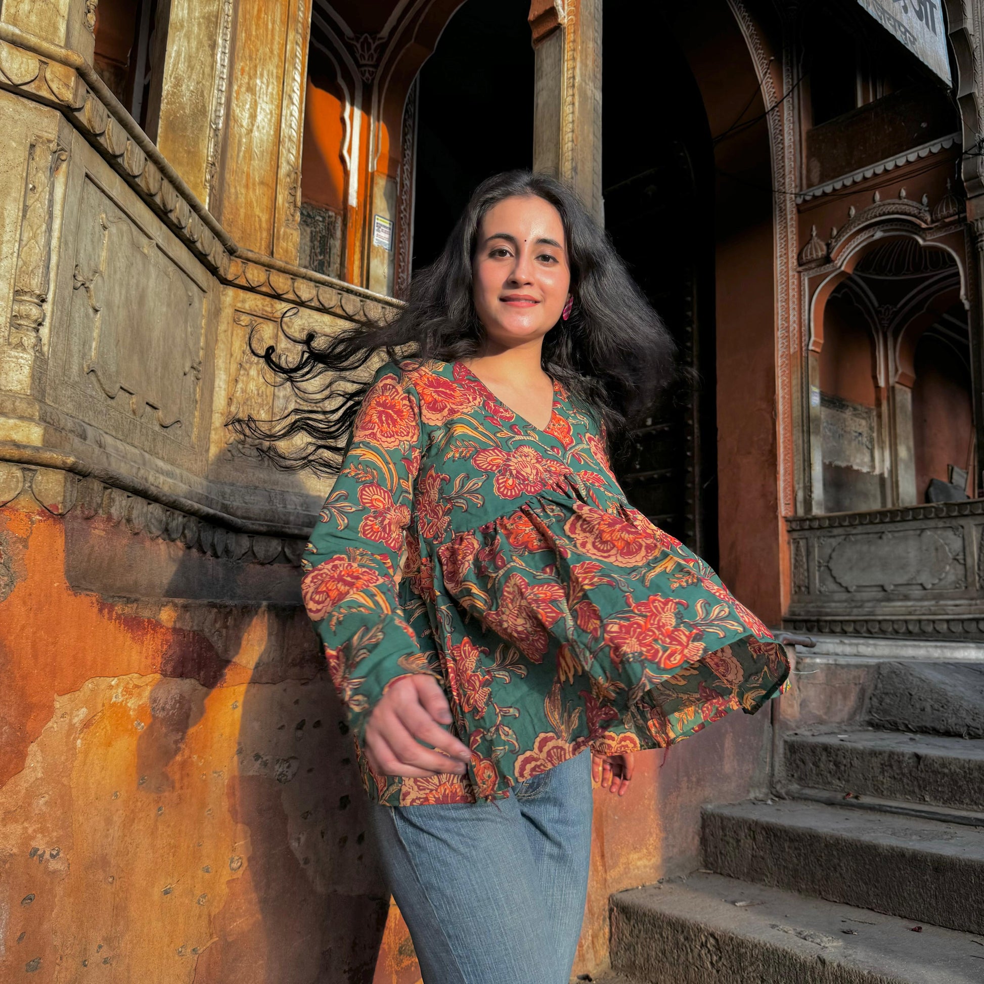 A woman wearing a green floral cotton peplum  top