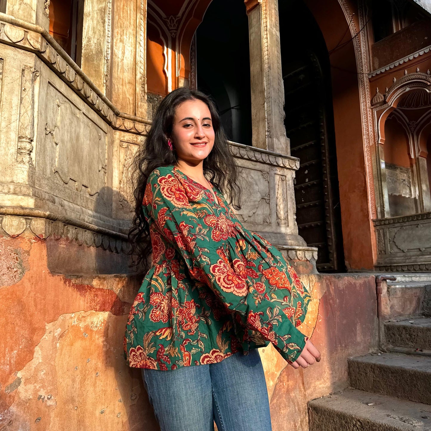A woman wearing a green floral cotton peplum  top
