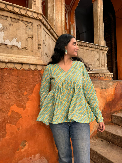  A woman wearing a  floral cotton peplum top green or yellow