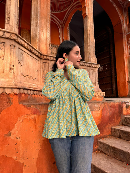  A woman wearing a yellow or green floral cotton peplum top