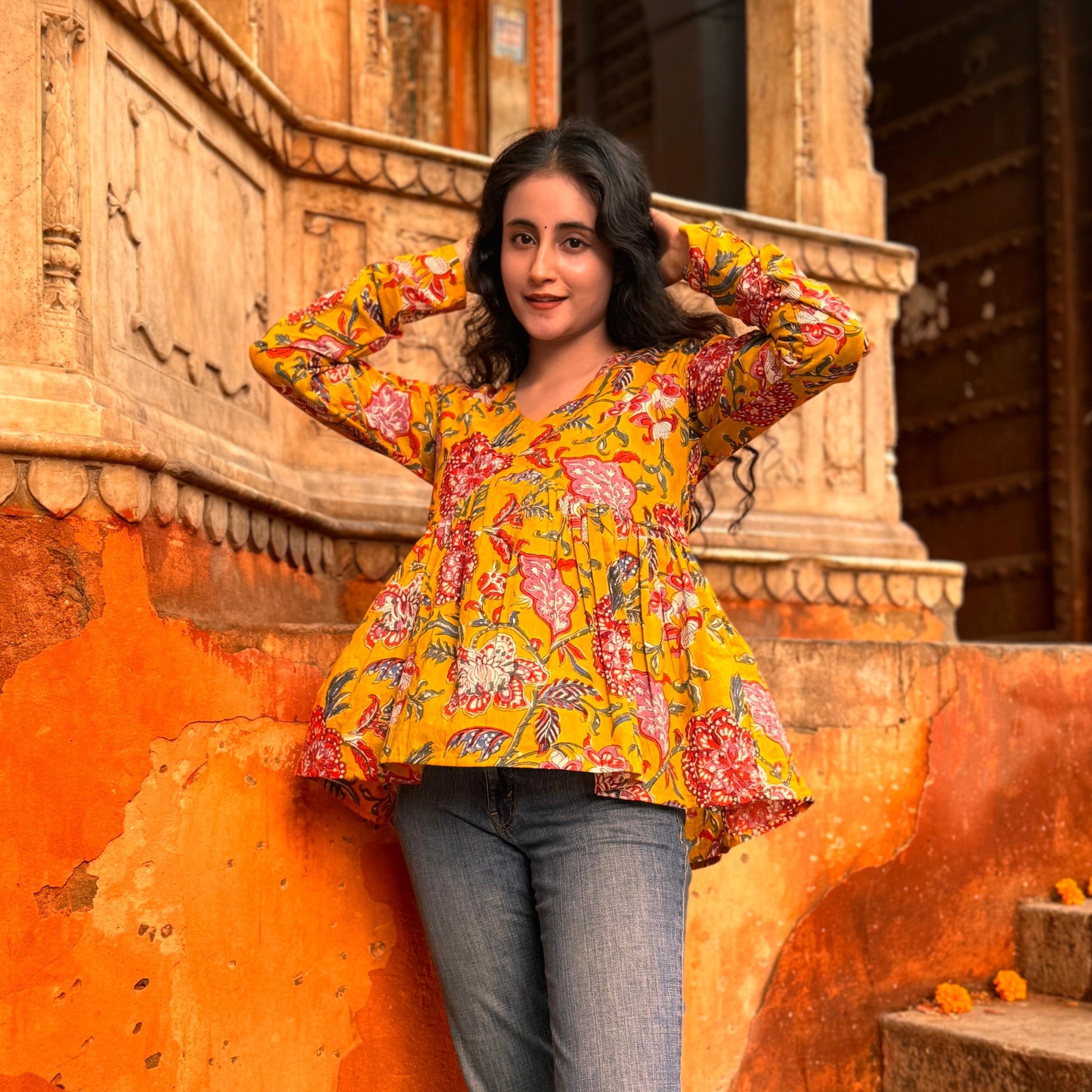 A woman wearing a yellow floral cotton top