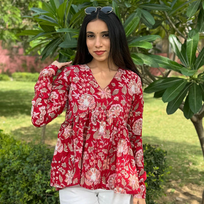 A woman wearing a red floral cotton top