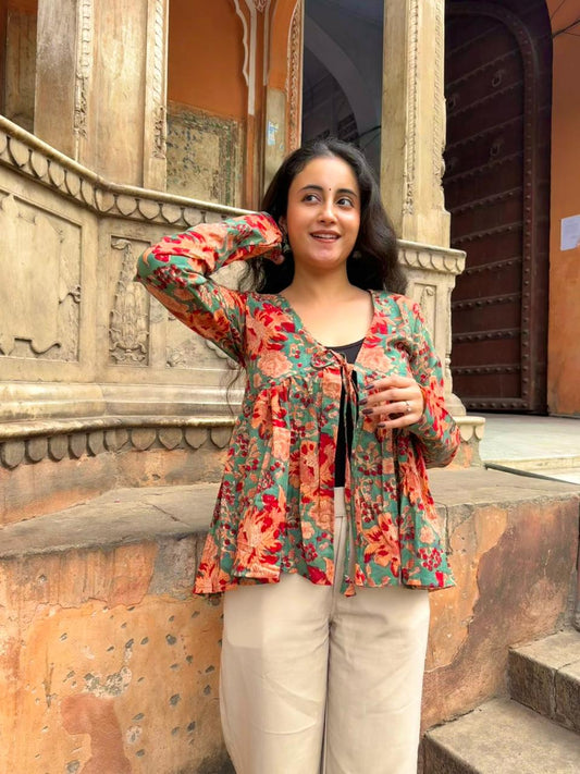 Woman in a floral jacket standing in front of an architectural structure