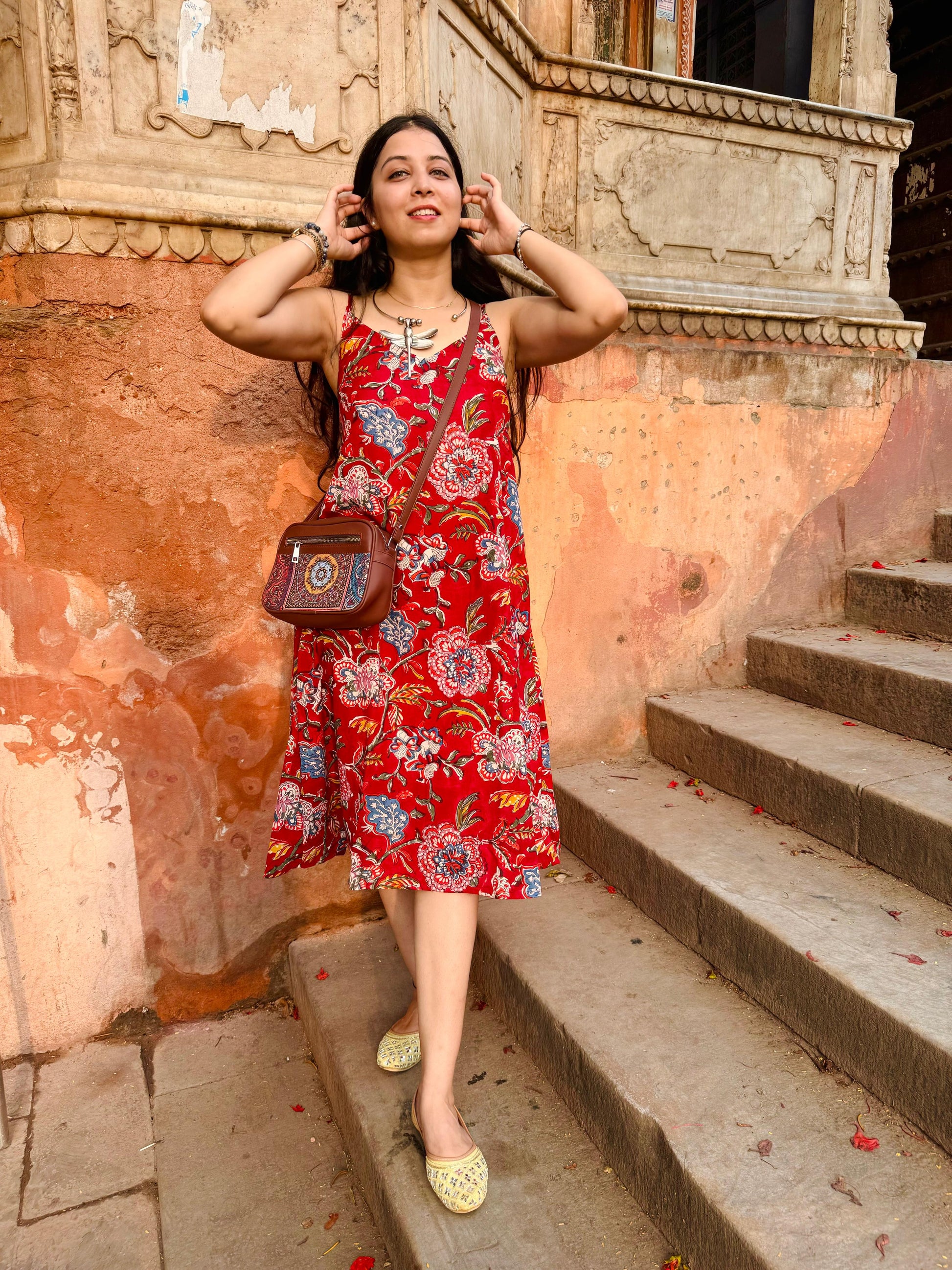 A woman wearing a red floral cotton  summer dress