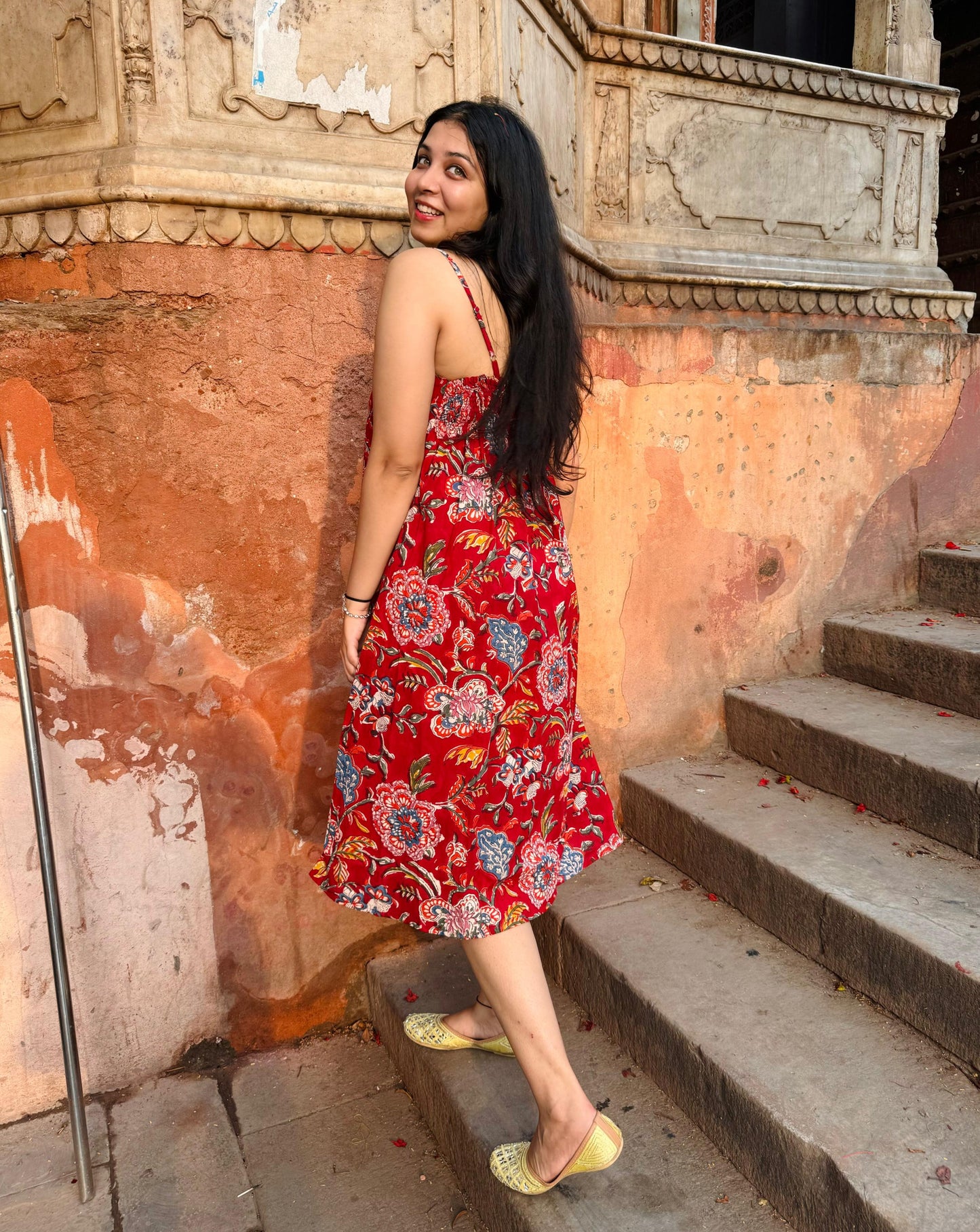 A woman wearing a red floral cotton  summer dress