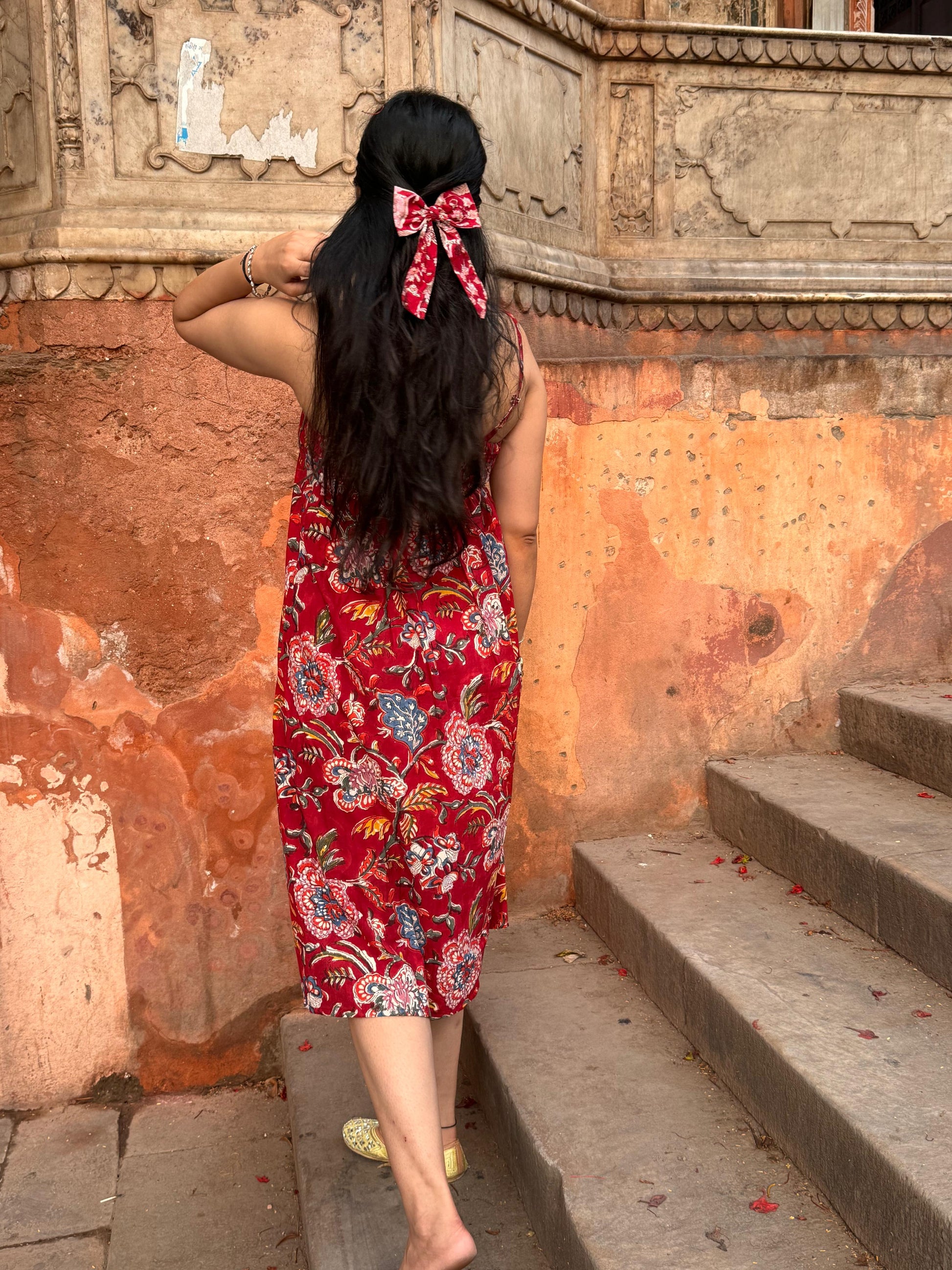 A woman wearing a red floral cotton  summer dress