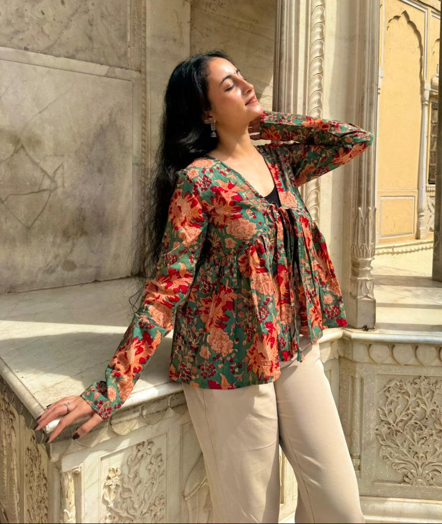 Woman in a floral blouse standing in an architectural setting