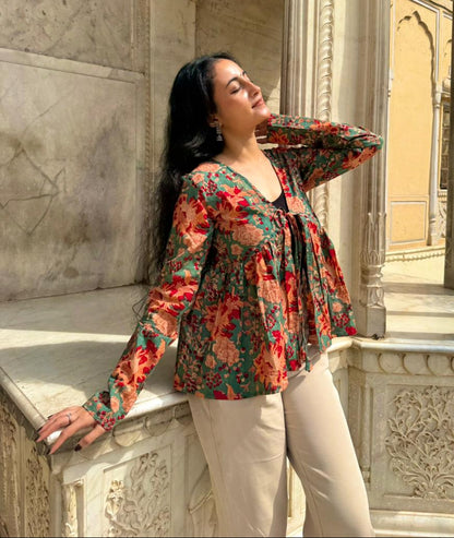 Woman in a floral blouse standing in an architectural setting