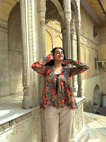 Woman in a floral blouse standing in an ornate architectural setting