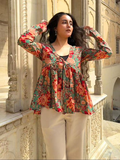 Woman in a floral blouse standing in front of an architectural building