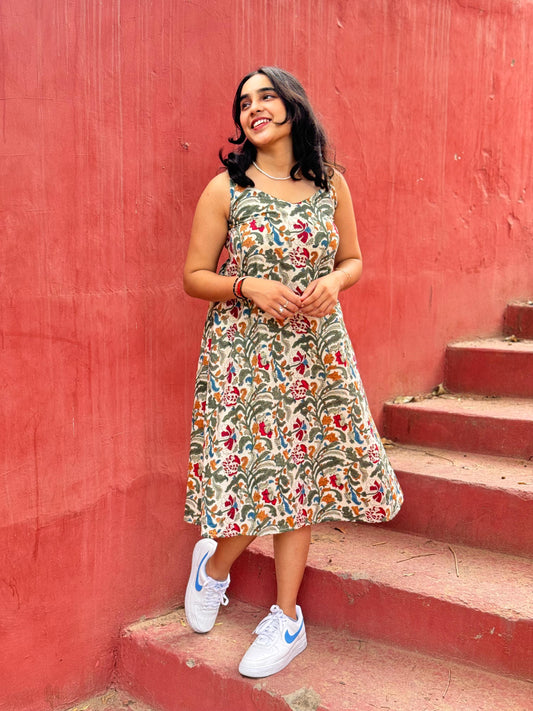 A woman standing on a set of stairs, wearing a floral hand block printed summer dress.