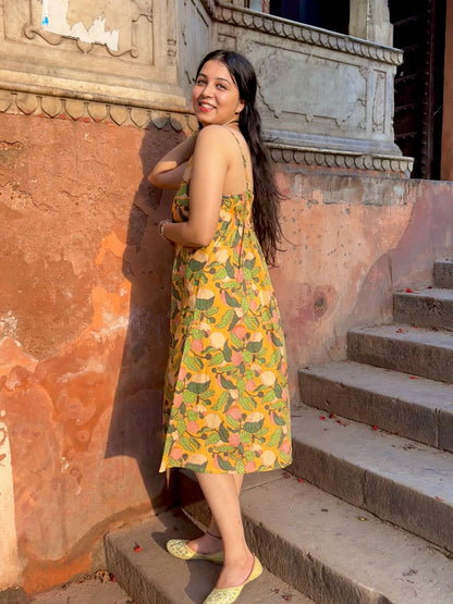 A woman wearing a yellow floral cotton  summer dress