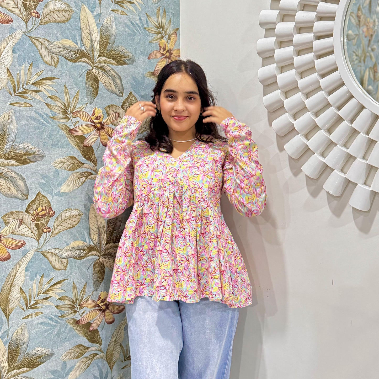 A woman wearing a pin floral cotton peplum  top