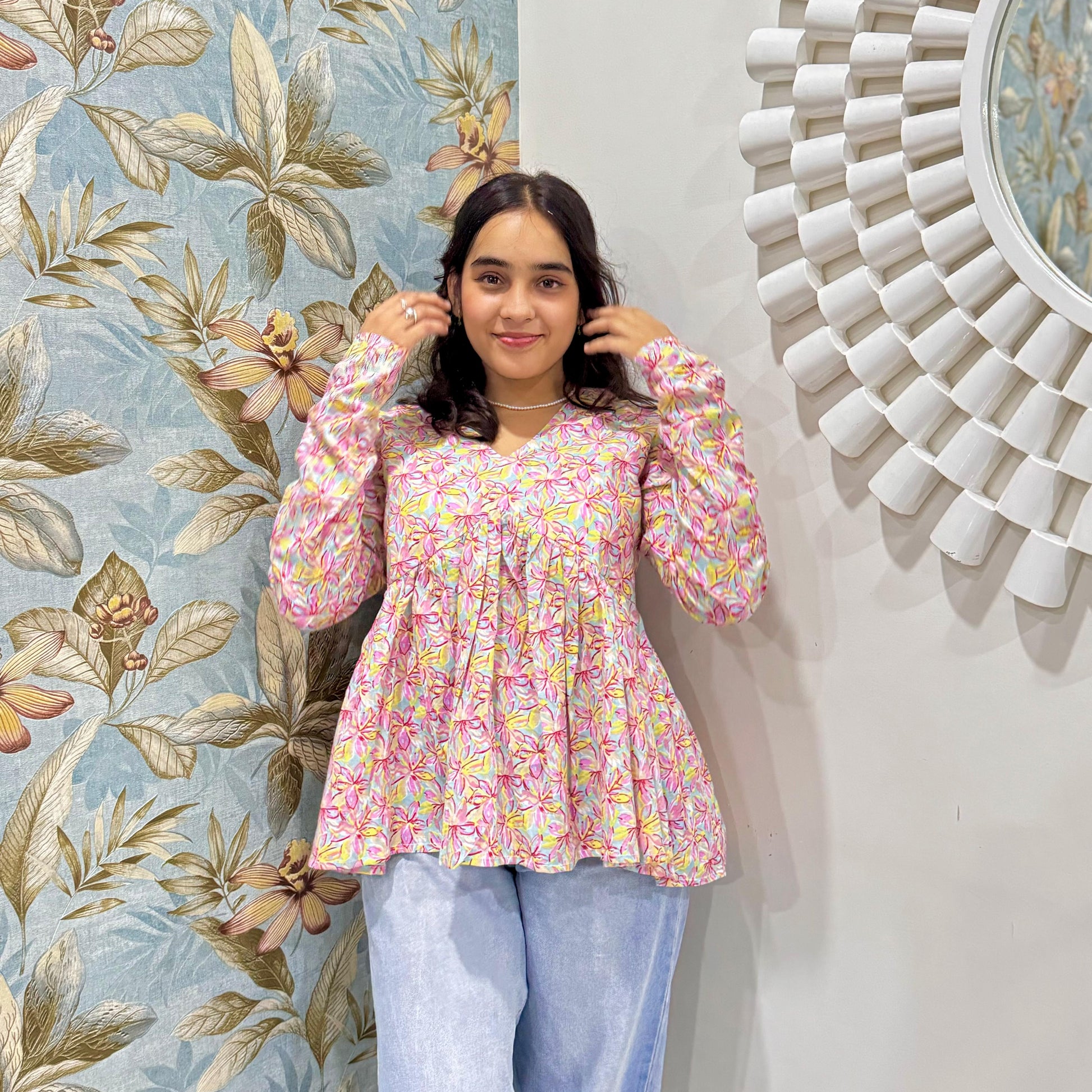 A woman wearing a pin floral cotton peplum  top