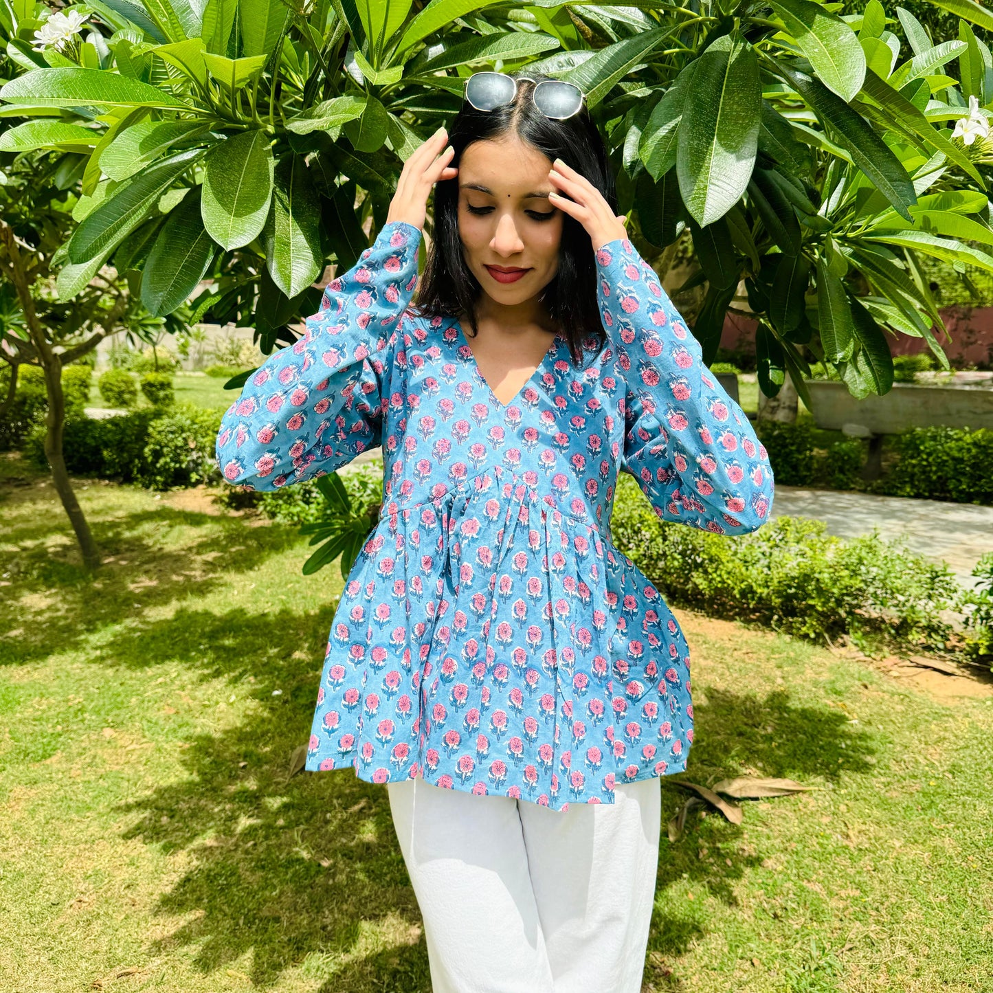 A woman wearing a blue floral cotton top