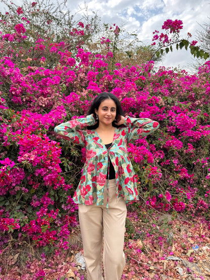 Woman standing in front of a vibrant pink flowering bush