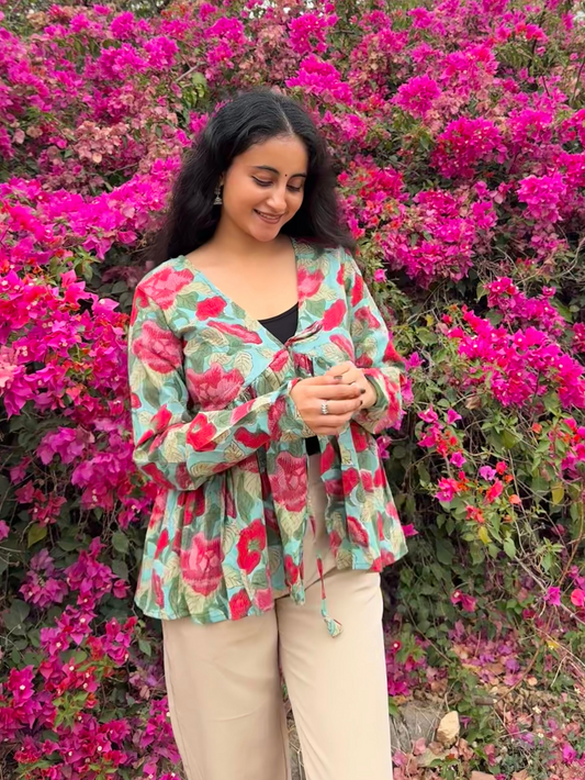 Woman standing in front of a bush with pink flowers