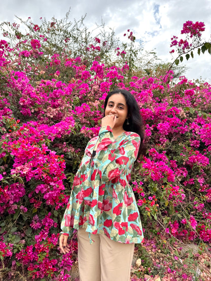Woman standing in front of a vibrant pink flowering bush