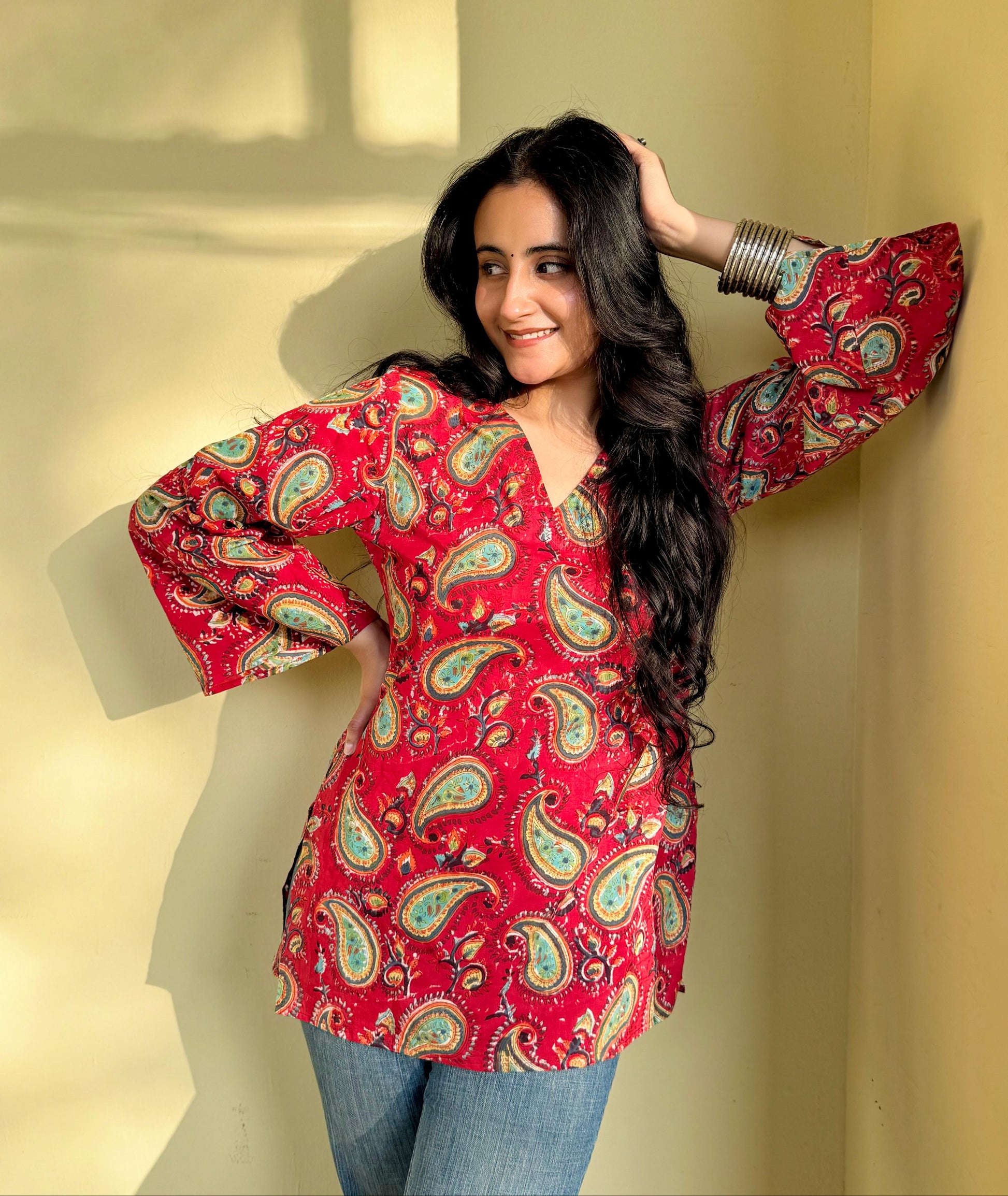 A woman wearing a red floral cotton short kurti