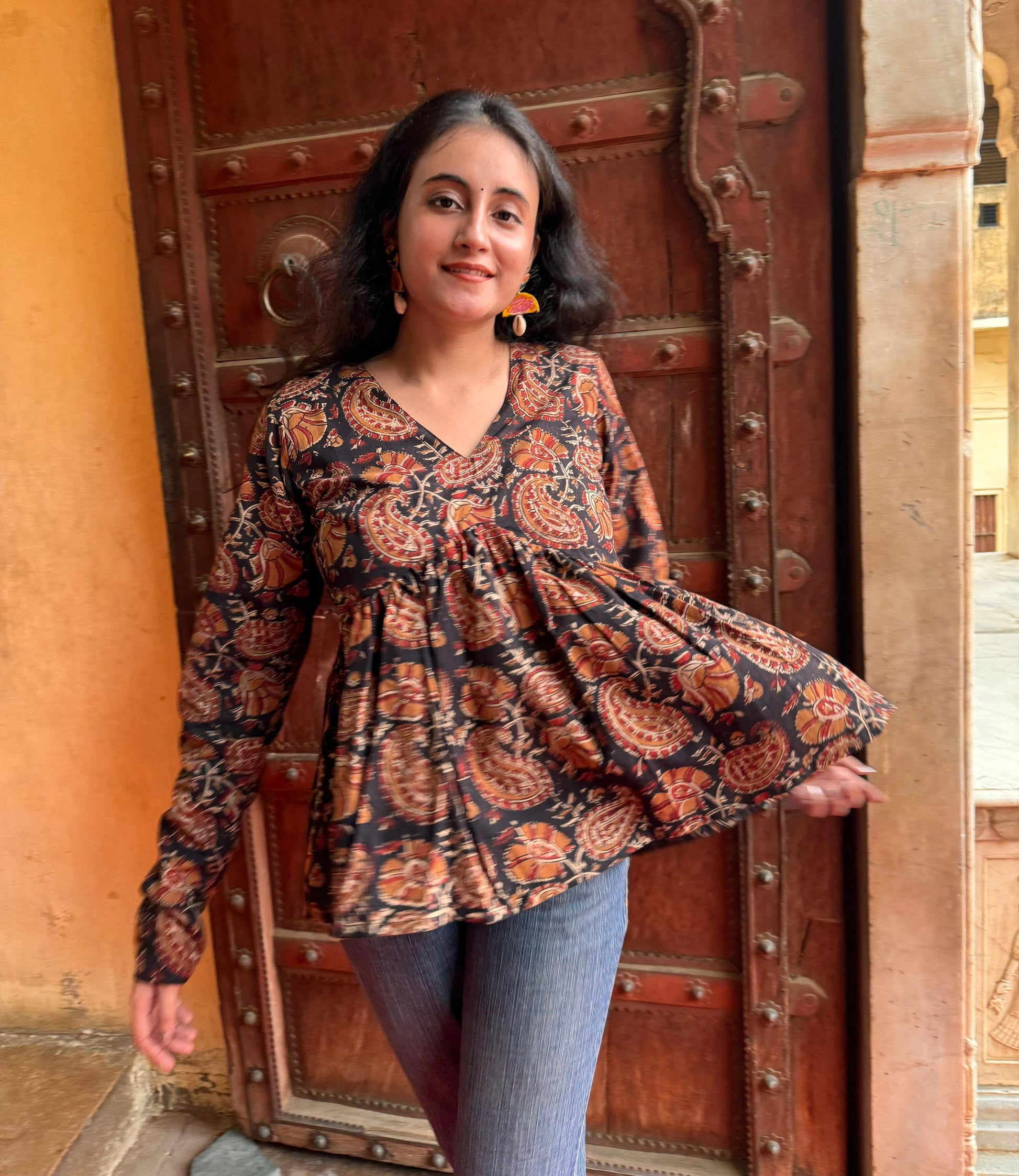 A woman wearing a black floral cotton top