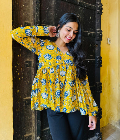 A woman wearing a yellow floral cotton top