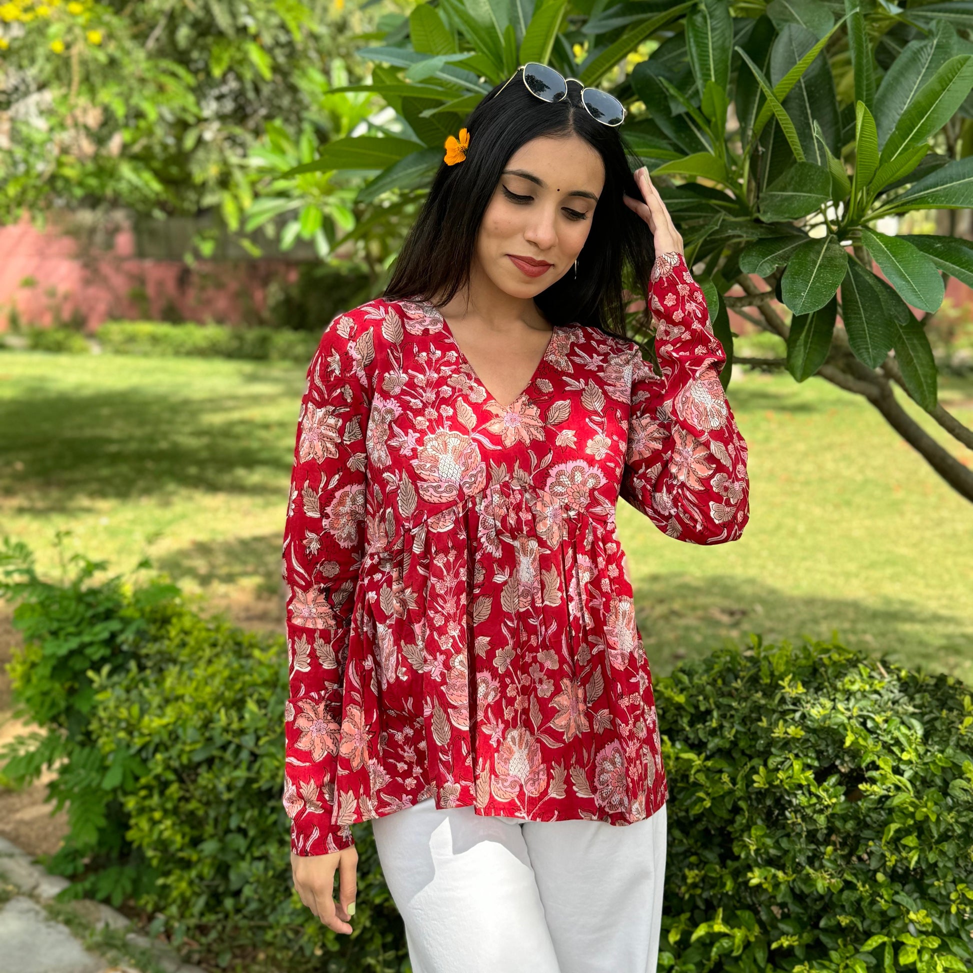 A woman wearing a red floral cotton top
