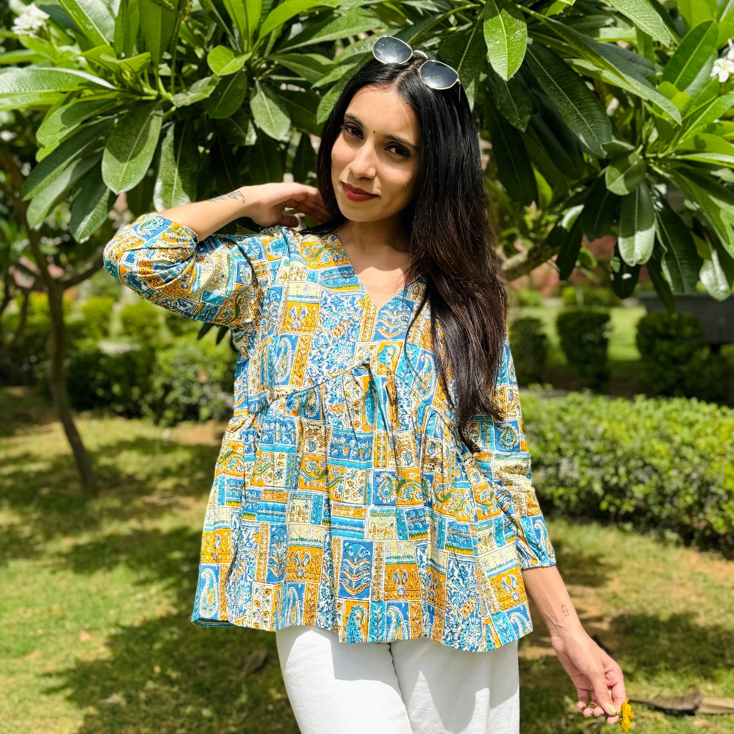 A woman wearing a printed floral cotton top