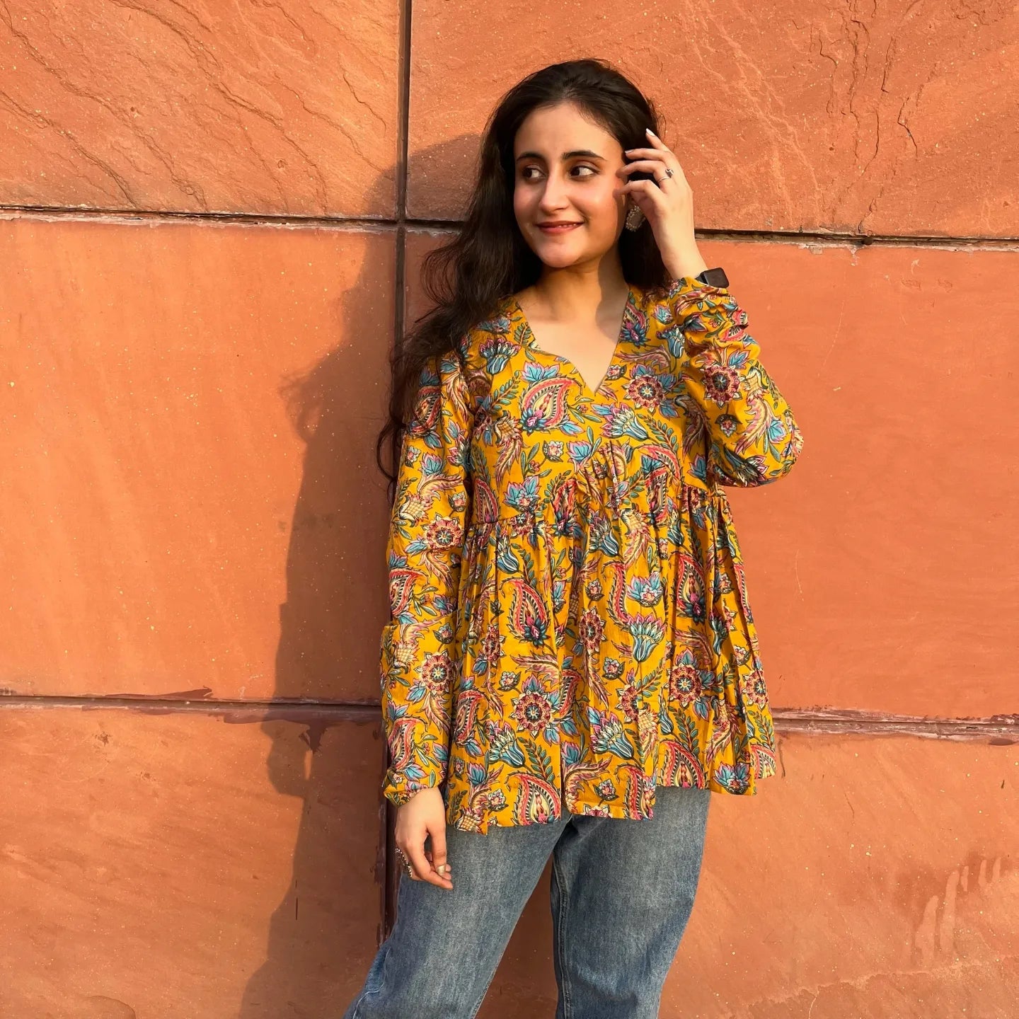 A woman wearing a floral cotton yellow top