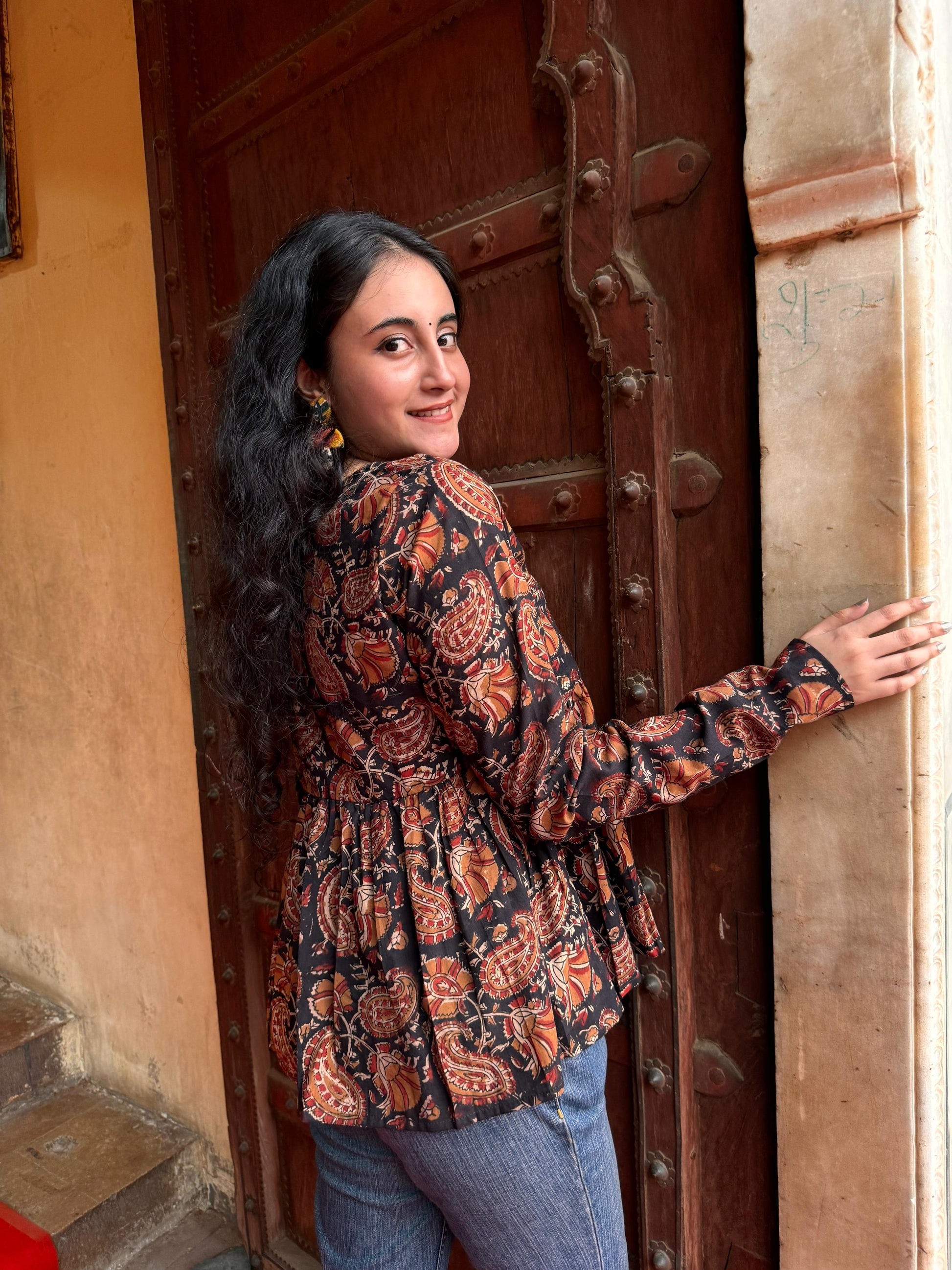 A woman wearing a black floral cotton top