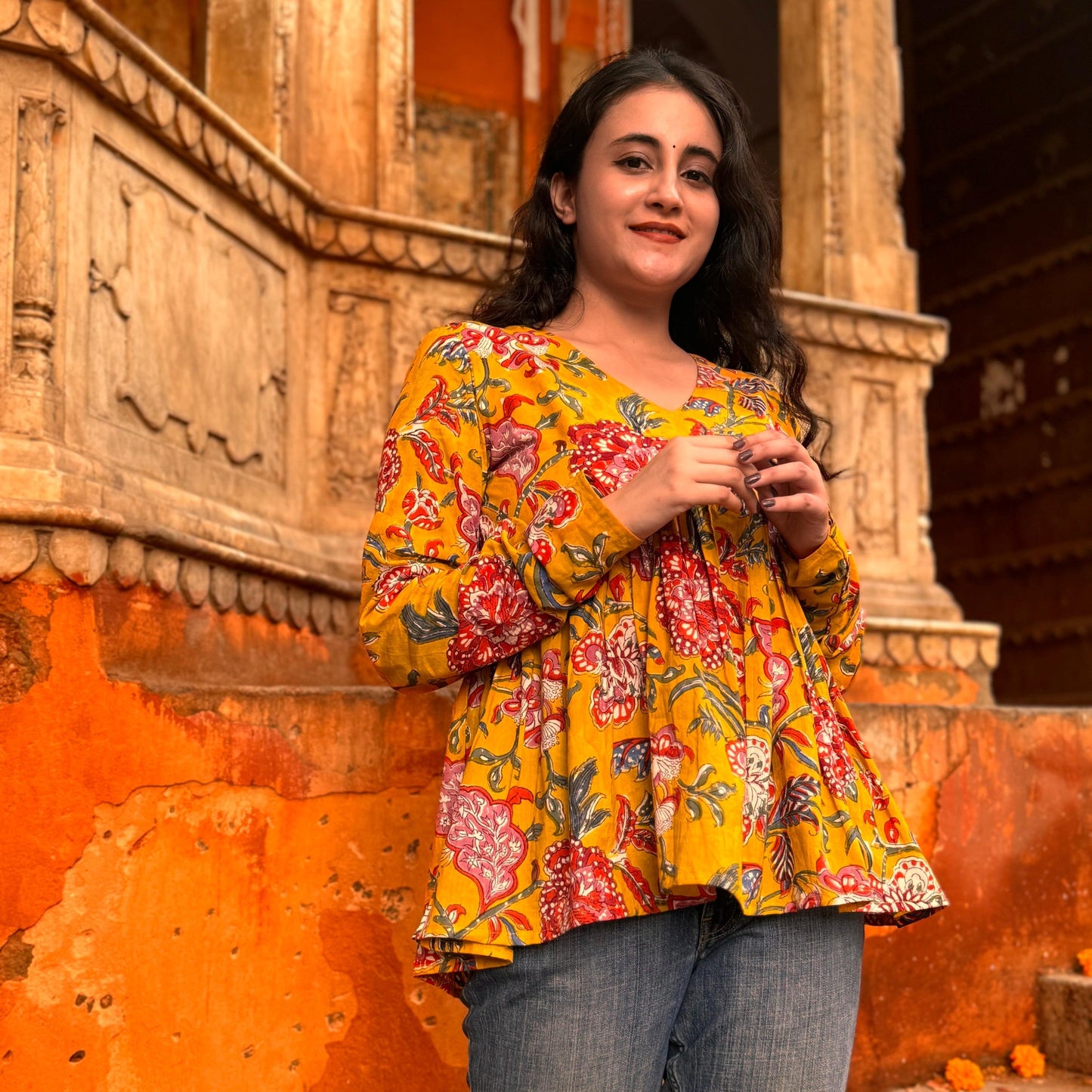 A woman wearing a yellow floral cotton top