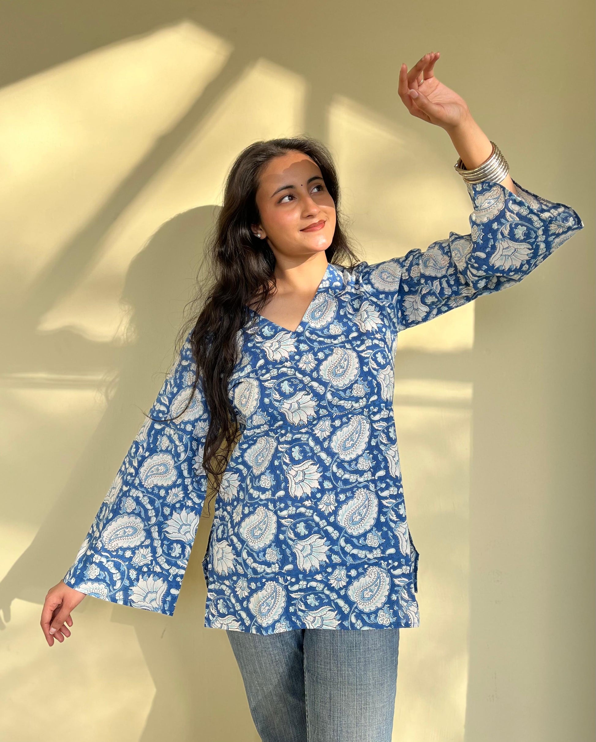 A woman wearing a blue floral cotton  kurti