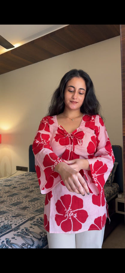 Woman wearing a red and white floral dress in an indoor setting