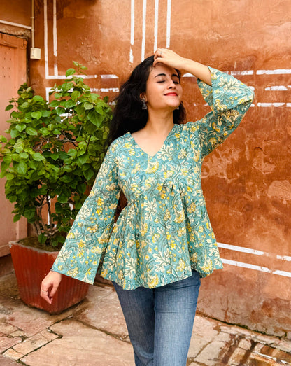 Woman wearing a floral blouse against a textured wall