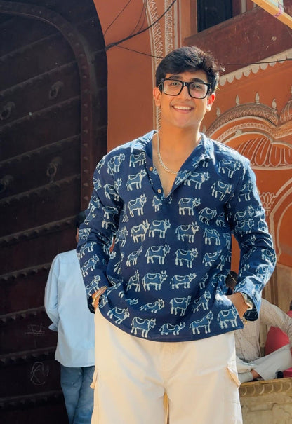 Person wearing a blue patterned shirt with a decorative background
